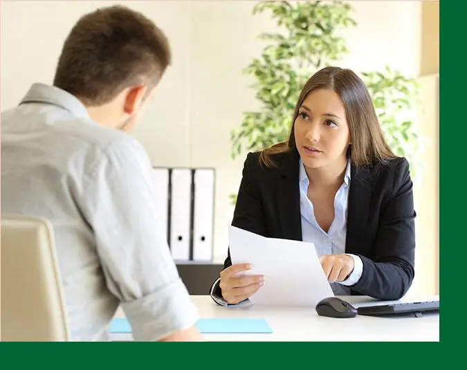 A woman is interviewing someone in an office setting.